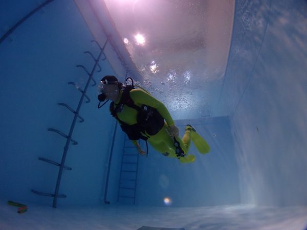 水深-4ｍあるプールで1人のダイバーがダイビングしてる写真