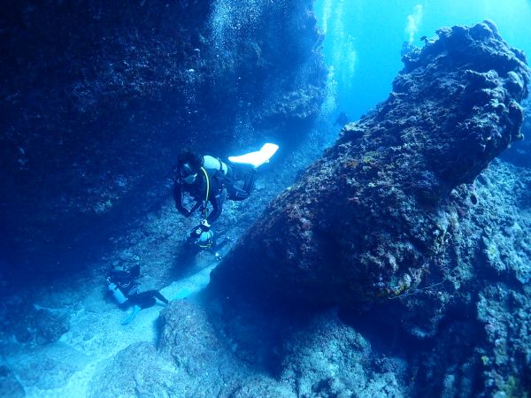 海中の水路を泳ぐダイバー