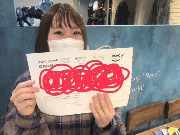 合格したテスト用紙をもってる写真
