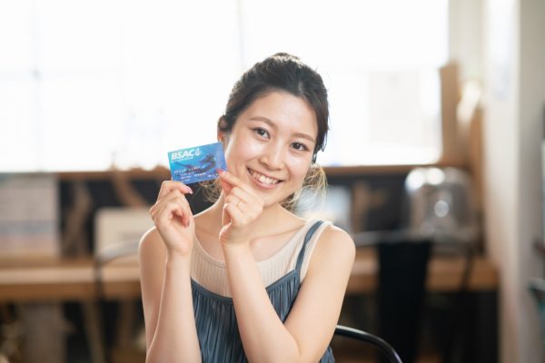ダイビングライセンスカードを手にする若い女性