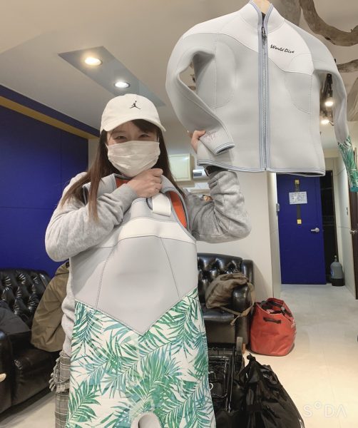 WETスーツを持つ女性ダイバー